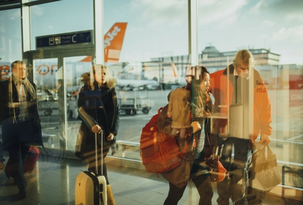 Travellers walking through an airport with suitcases. Photo by Negative Space, Pexels.