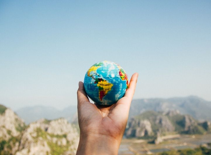 Hand holding a small globe