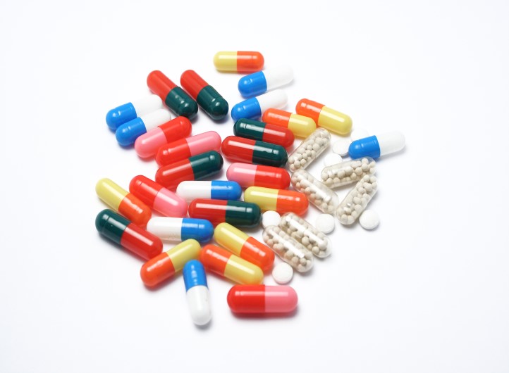 Assorted colourful pills on white background